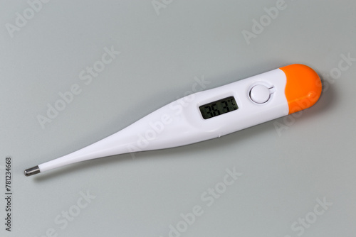 Electronic medical thermometer on a gray surface © An-T
