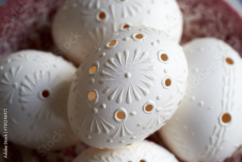 White Easter eggs decorated with wax with drilled holes, closeup