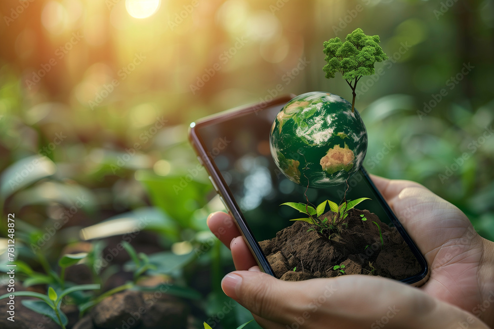 Man hand holding smartphone with tree growing on earth.