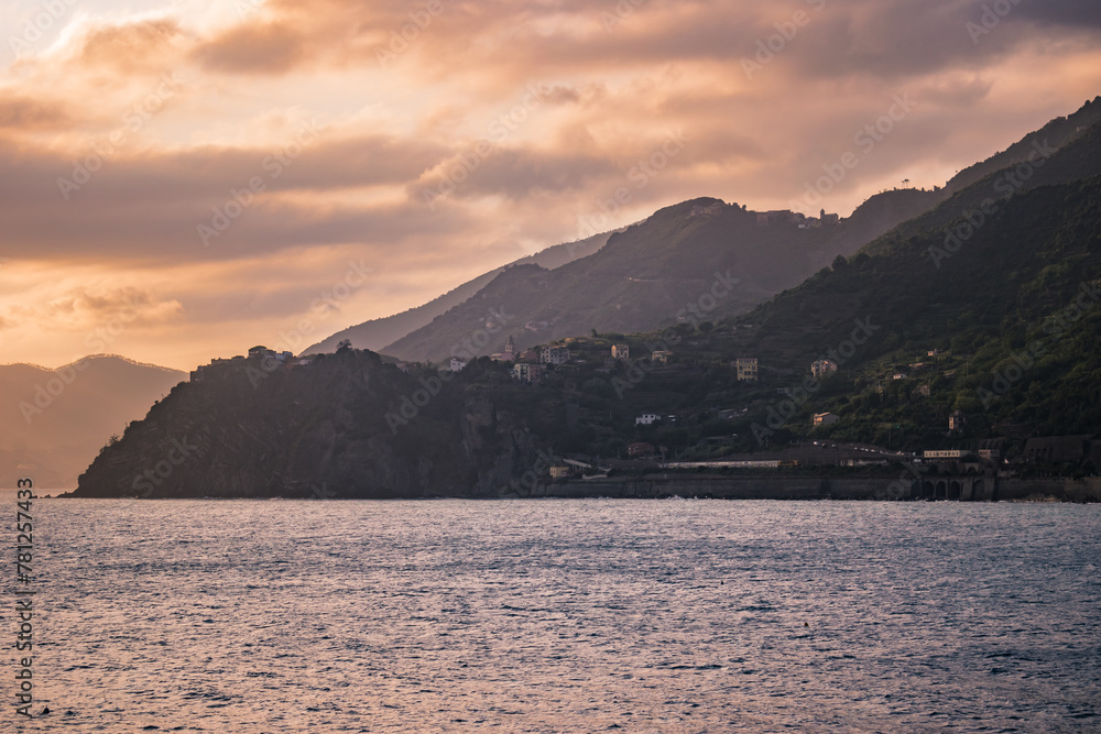 Mountains with mediterranean Corniglia village in lowlight and gradient in horizon at sunset, Cinque Terre ITALY