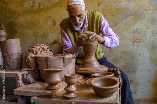 Elderly artisan crafting traditional pottery photo