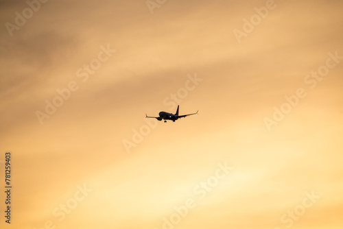 Airplane flying in the sky at sunset