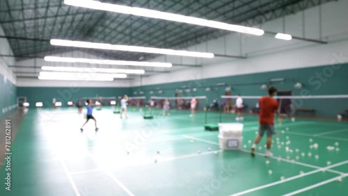 Blurred environment view of a badminton gym while people play and learn the indoor game. photo
