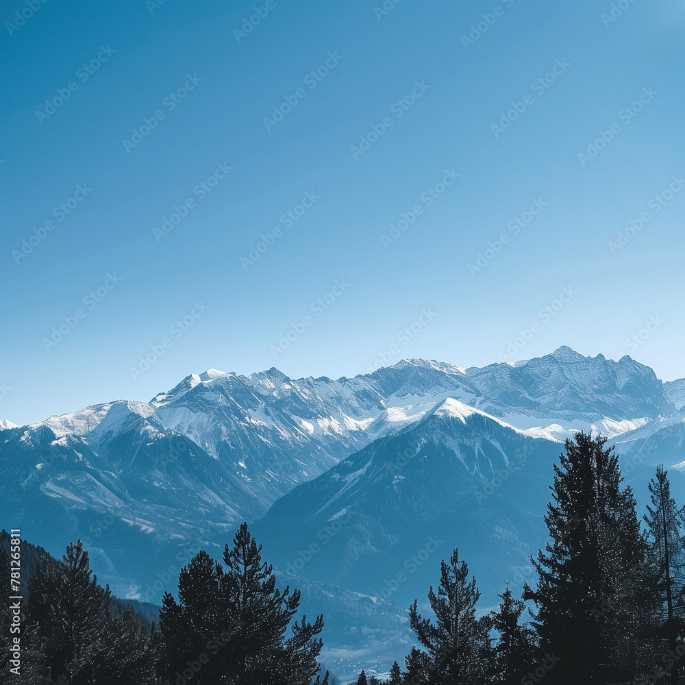 Majestic Snow-Capped Mountain Range Under Clear Blue Sky. Scenic Winter Landscape with Pine Trees in Foreground and Serene Atmosphere. Majestic Snow-Capped Mountain Range Under Clear Blue Sky. Scenic Winter Landscape with Pine Trees in Foreground and Serene Atmosphere.