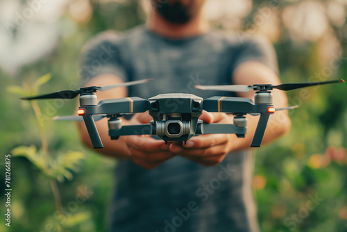 Man holding quadcopter on green nature background