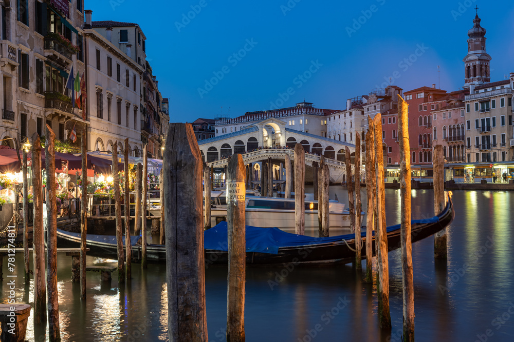 Blick auf die Rialtobrücke am Abend, in der blauen Stunde schwiemen Gondeln am Canal Grande, Venedig ist bereits beleuchtet