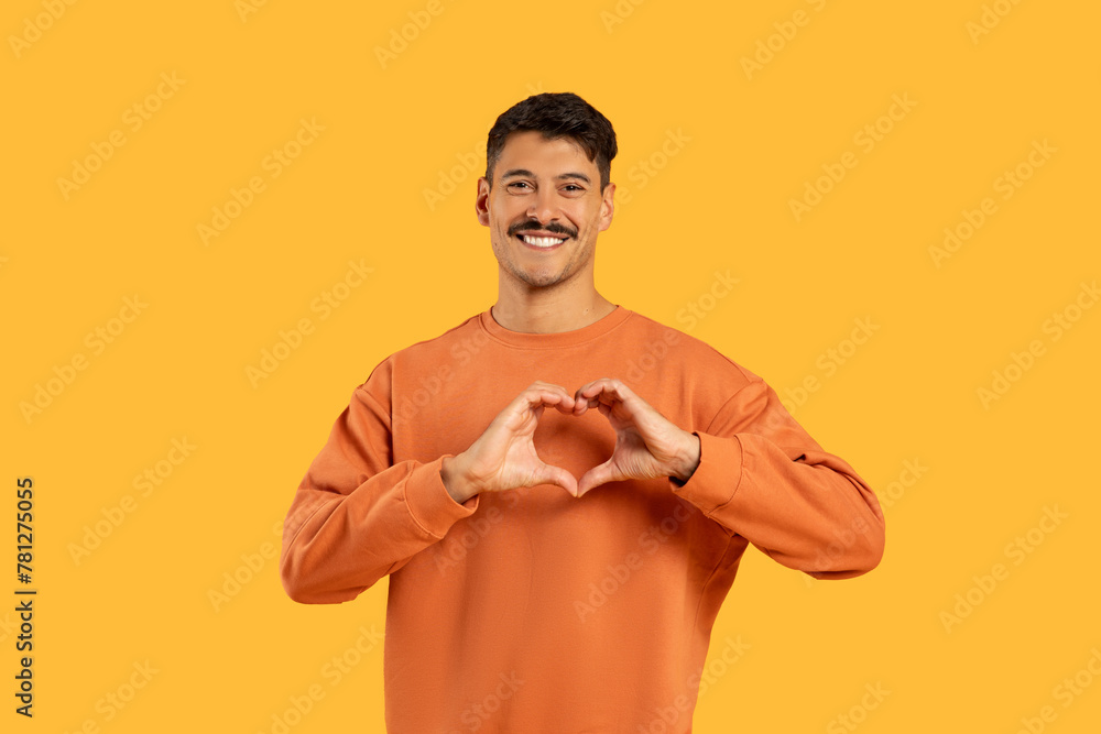 Man with moustache making heart shape with hands - obrazy, fototapety, plakaty 