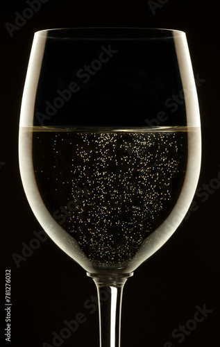 Glass of sparkling wine on black background