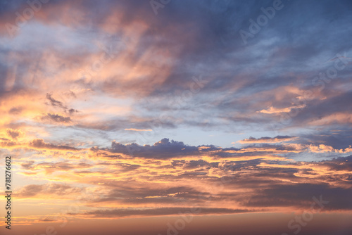The sky at sunset showcases a mesmerizing array of orange and blue hues, with clouds illuminated in a soft glow, making it an ideal choice for backgrounds or sky replacements © Artem