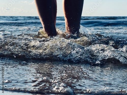 feet in the water on the beach