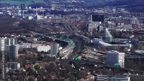 Aerial footage of transport infrastructure in city. Busy highway and multitrack railway line leading around football stadium and residential urban borough. Basel, Switzerland photo