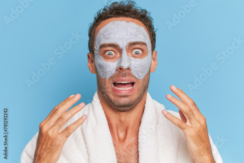 a man wearing a bathrobe and a face mask is making a funny face