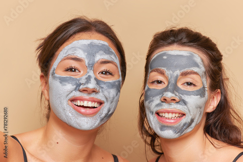 Two women wearing face masks, smiling with happy facial expressions