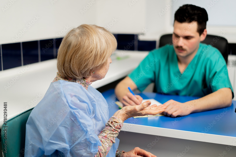 Fototapeta premium in a plastic surgery clinic a doctor consults an elderly woman making notes on paper