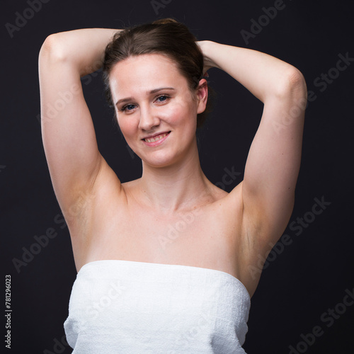 Brunette woman in a white towel with your hands up