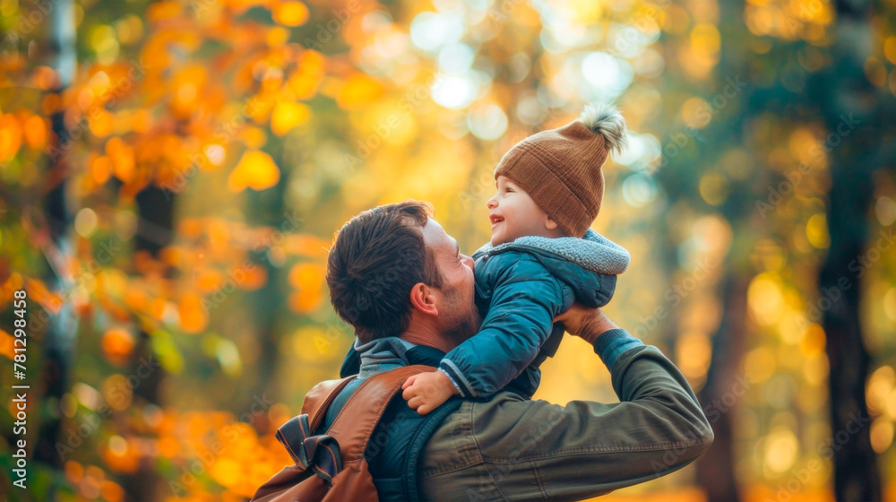 A man father holds a small smiling child son in his arms against the backdrop of an autumn forest. Attitude of children and parents. Father's Day. Banner. Copy space