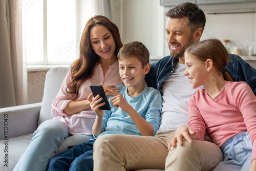 Family interacting with smartphone together at home