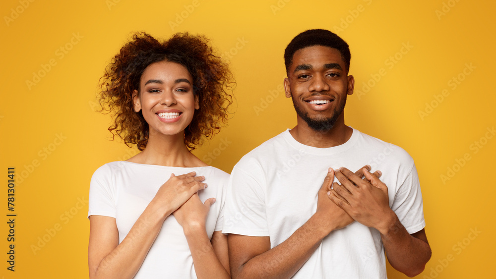 Kind woman and man keep both palms on chest Kind woman and man keep both palms on chest