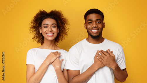 Kind woman and man keep both palms on chest