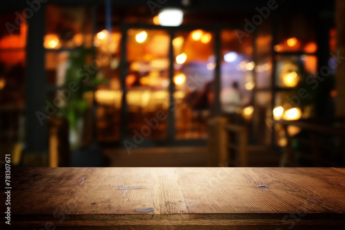 image of wooden table in front of abstract blurred background of restaurant lights © tomertu