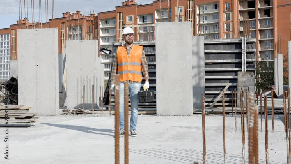 Repairman worker in uniform and helmet holding cordless screwdriver, standing on his workplace Repairman worker in uniform and helmet holding cordless screwdriver, standing on his workplace