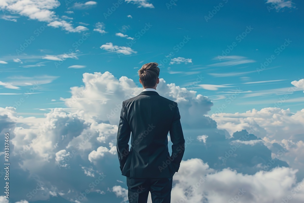 Back view of businessman standing on the top of mountain hike over blue sky, sunlight. Man in suit looking forward on the peak. Concept of leadership successful achievement with goal, growth up, win Back view of businessman standing on the top of mountain hike over blue sky, sunlight. Man in suit looking forward on the peak. Concept of leadership successful achievement with goal, growth up, win