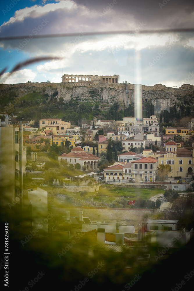 Obraz premium Stunning view of Acropolis and vibrant buildings under clear blue sky, captured on a sunny day in Athens