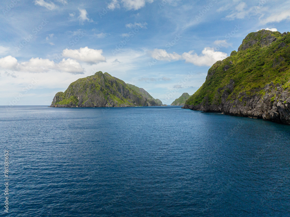 Blue sea and Islands under blue sky and clouds in El Nido. Tapiutan and Matinloc. Philippines.