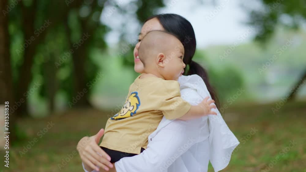 Asian mothers or single moms are smiling and hugging newborn babies. Family doing activities and relaxing in the park. Concepts about the duties of a wife and mother in raising children and family. Asian mothers or single moms are smiling and hugging newborn babies. Family doing activities and relaxing in the park. Concepts about the duties of a wife and mother in raising children and family.