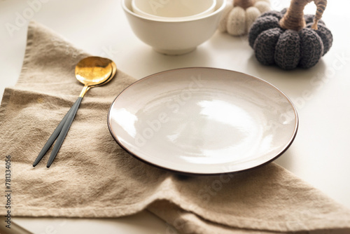 Dinner table setting with white plates and decorative knite pumpkins on white table top view.