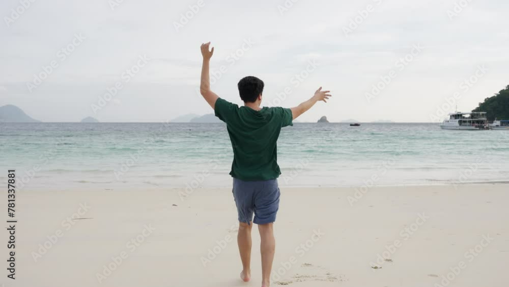 Asian man bursts with excitement, running along the sandy beach with hands waving in exhilaration. Against the backdrop of crashing waves and golden sands, he energy and joy,. High quality 4k footage Asian man bursts with excitement, running along the sandy beach with hands waving in exhilaration. Against the backdrop of crashing waves and golden sands, he energy and joy,. High quality 4k footage