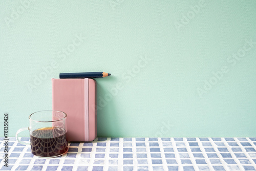 Obraz na płótnie Diary notebook, pencil, coffee on blue tile desk. mint wall background. workspace w salonie