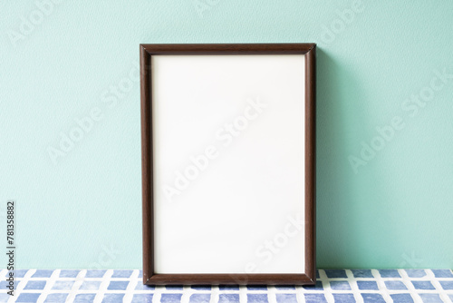 Obraz na płótnie Wooden picture frame on blue tile shelf. mint wall background. copy space w salonie