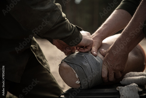 Ukrainian soldiers train to apply a bandage on a dummy wounded leg