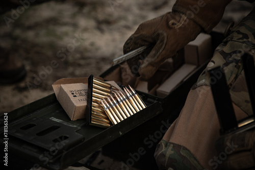Soldier hands with 5.56 bullets cartridge photo