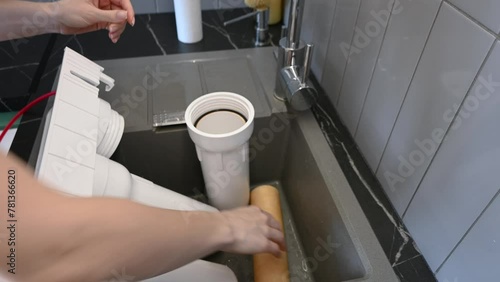 Woman installing water filter cartridges in a kitchen. Installation of water purification system