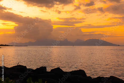 The island of Mo'orea is seen in the distance under a spectacular sunset from the capital of French Polynesia, Papeete, on the South Pacific island of Tahiti. photo