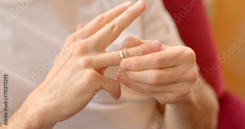 Close-up of hand removing wedding ring, symbolizing union dissolution. Emotional separation concept. Male hand removes wedding ring, signifying end of union. feelings of loss, transition, and closure.