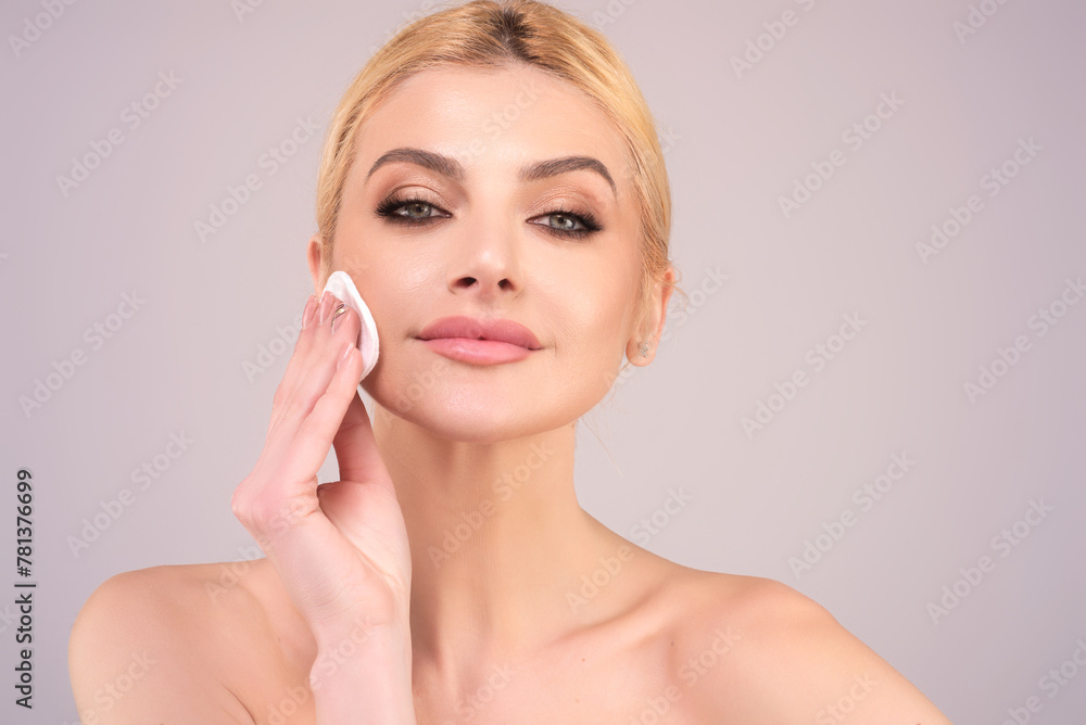 Woman removing makeup, holds cotton pads. Cleansing treatment care for skin with cotton pad. Young woman beauty model applying skin care product using a cotton pad.