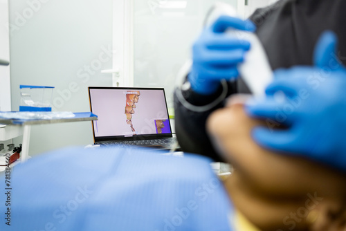Bild auf Leinwand An unrecognizable dentist uses an intraoral scanner to obtain 3D digital impressions of a patient's mouth and teeth
