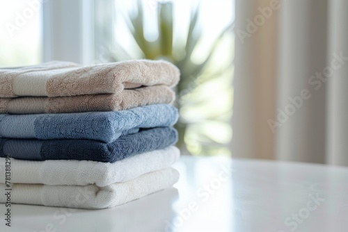 Close-up of neatly folded bath towels on a white table, creating a visually appealing arrangement with space for text.