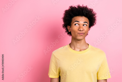 Photo of nice young man look empty space ponder wear yellow t-shirt isolated on pink color background