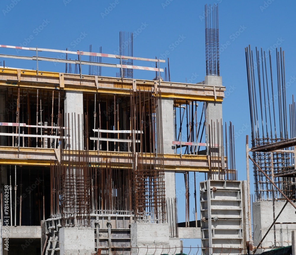 Baustelle mit Gerüst und Moniereisen vor blauem Himmel Baustelle mit Gerüst und Moniereisen vor blauem Himmel