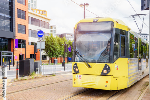 Yellow tram running along a street in a residential district