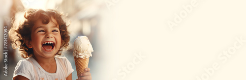 Happy little girl eating ice cream in a waffle cone against the backdrop of a sunny city street, cafe in summer.Banner. Copy space for text. Mockup photo