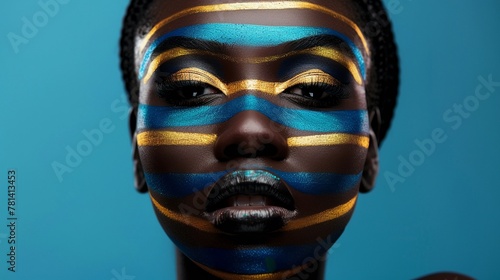 A portrait showcasing artistic makeup with bold metallic blue and gold stripes on an African womans face