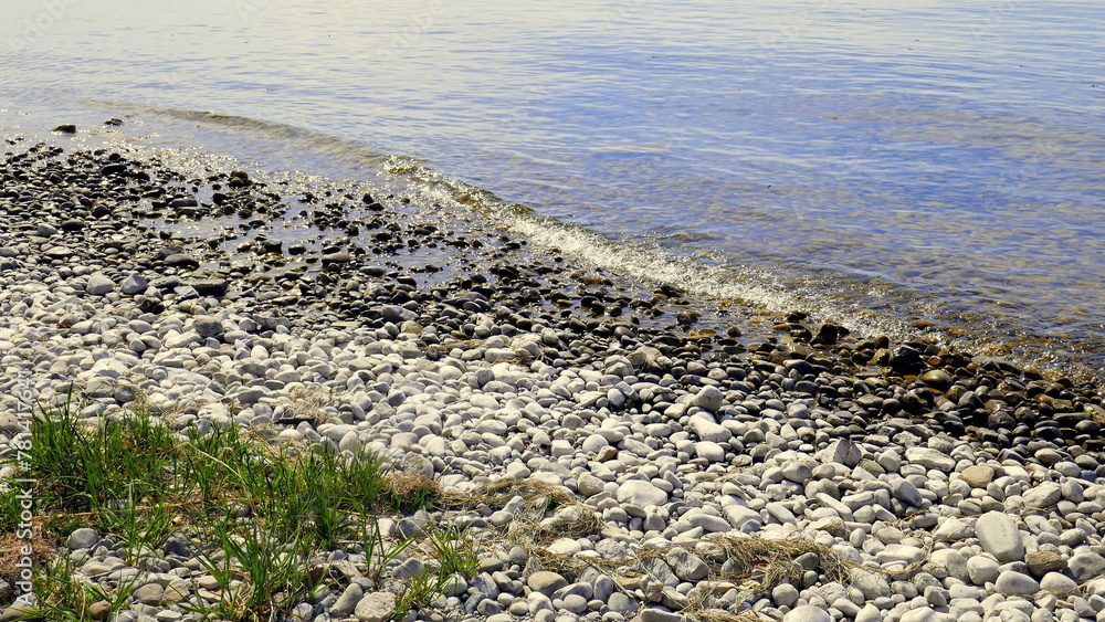 schönes Bodenseeufer mit weißen Kieselsteinen, Wasser und Wellen an sonnigem Tag schönes Bodenseeufer mit weißen Kieselsteinen, Wasser und Wellen an sonnigem Tag