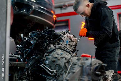 At a service station young master repairs a motor part removed from a car for a complete overhaul © Guys Who Shoot