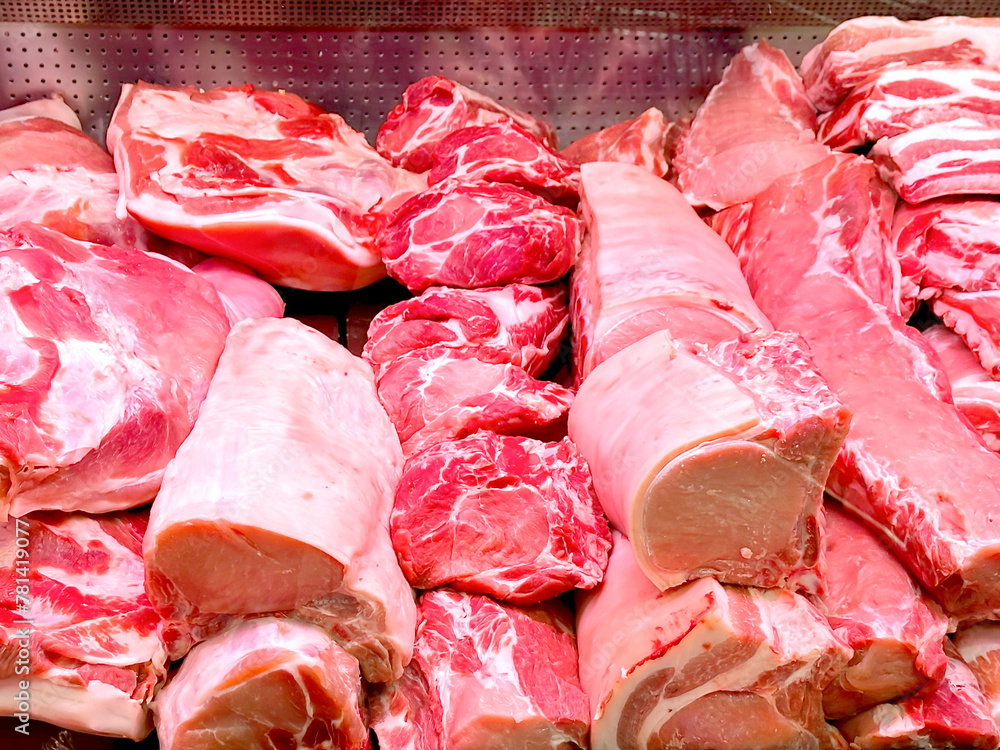 Pieces of fresh raw meat on the counter in a store, close-up. Meat background from pieces of beef and pork. Sale of meat products.