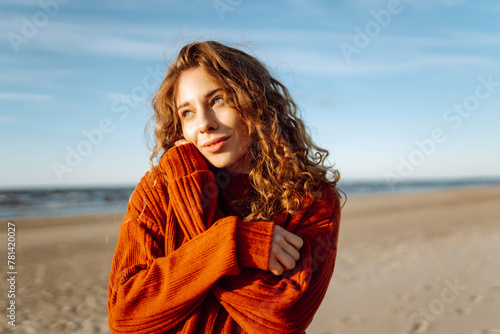 Outdoor portrait of pretty  woman on the beach  in cold sunny weather.  Travel, fashion, blogging concept. © maxbelchenko